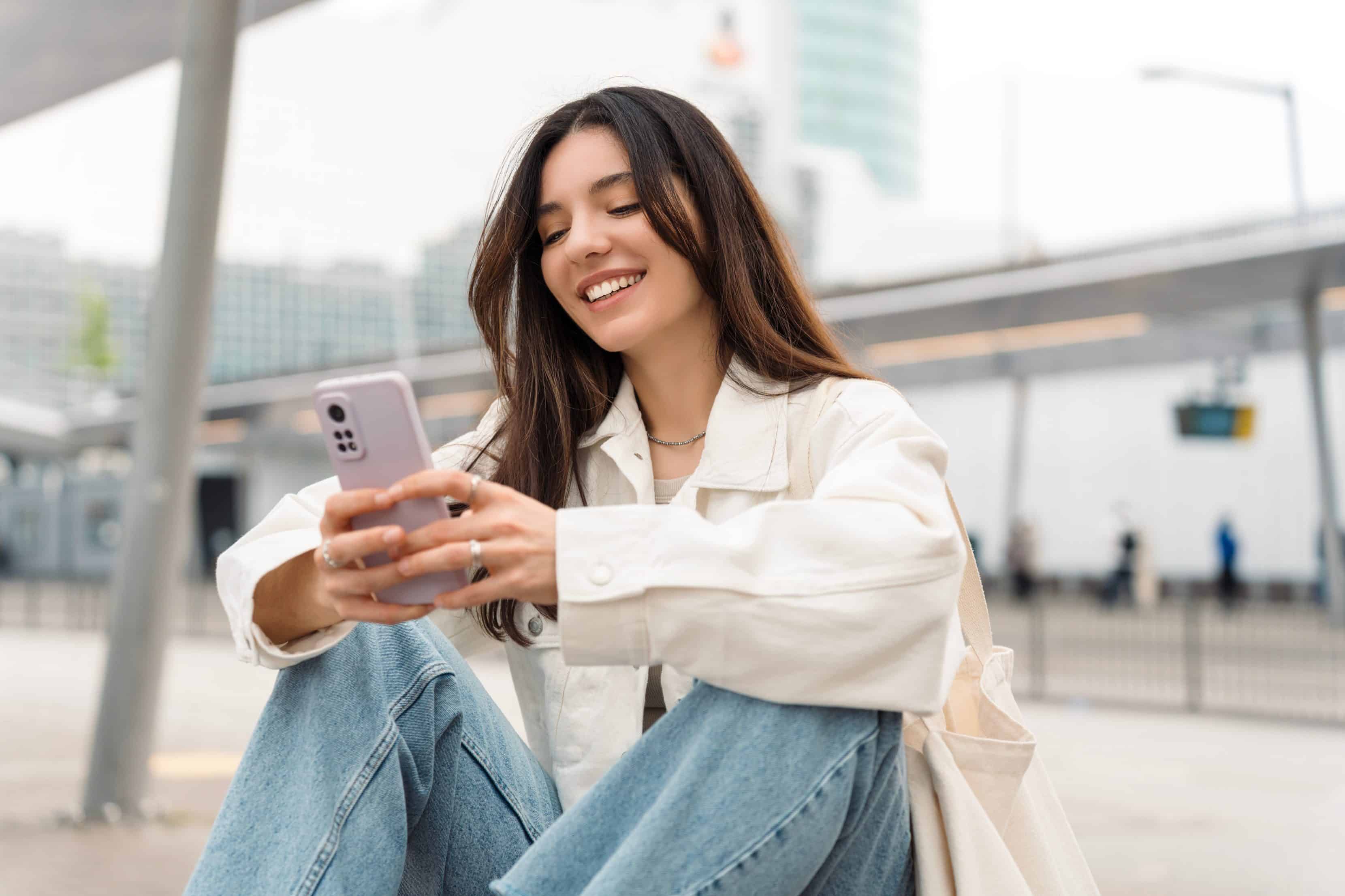 female entering dental insurance information into her phone during a dentall appointment at Highlands Periodontics and Implant Dentistry