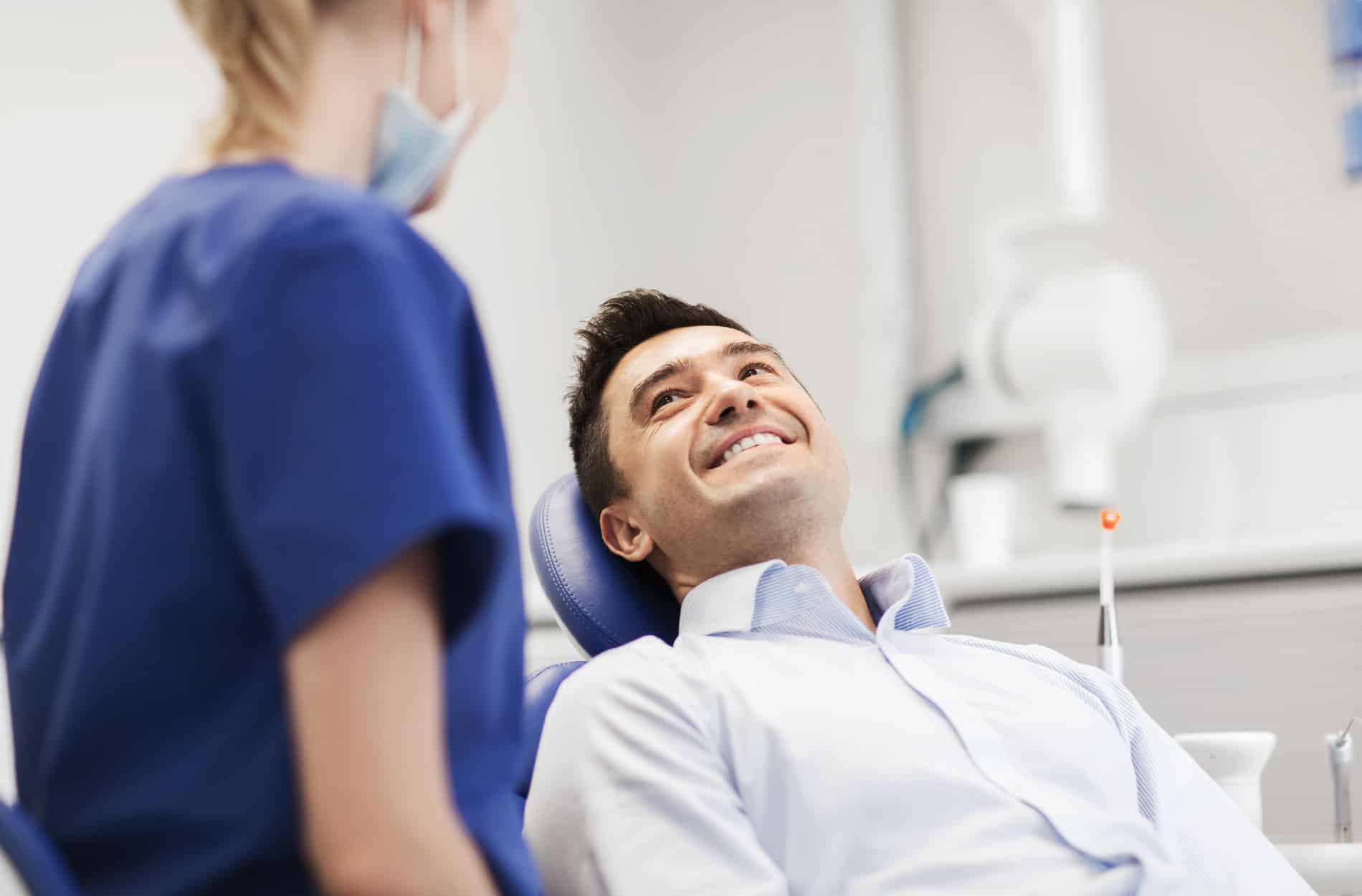 Man smiling and talking to Dr. Till about his implant overdentures in Kingsport